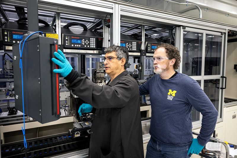 Two U-M researchers operating equipment inside the U-M Battery Lab
